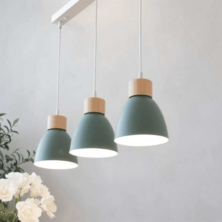 Row of three dark green pendant lights with wood detail for contemporary interiors