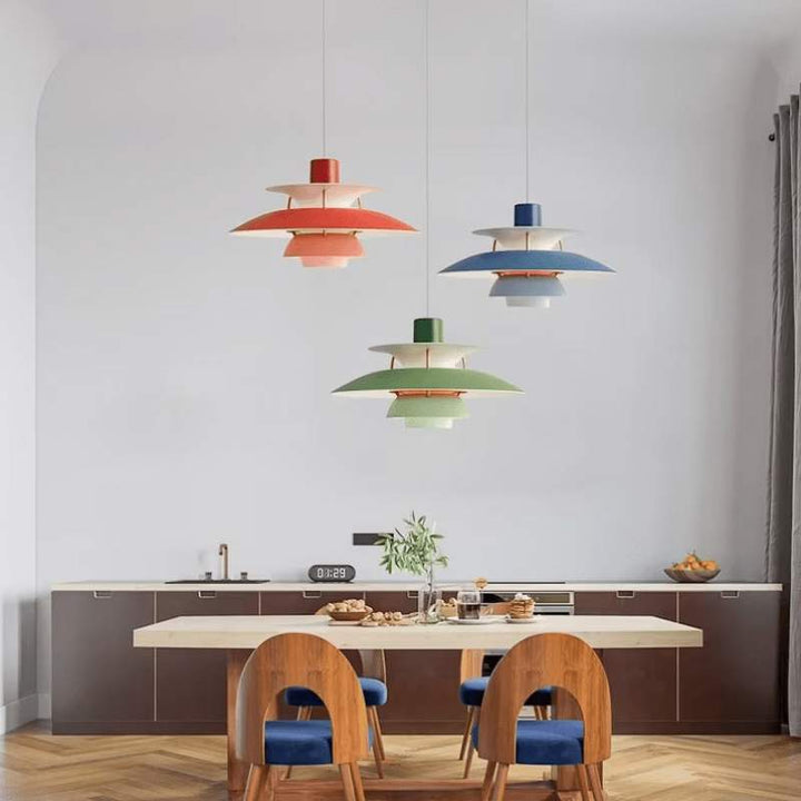 Colorful Nordic pendant lights hanging above a kitchen table with chairs.
