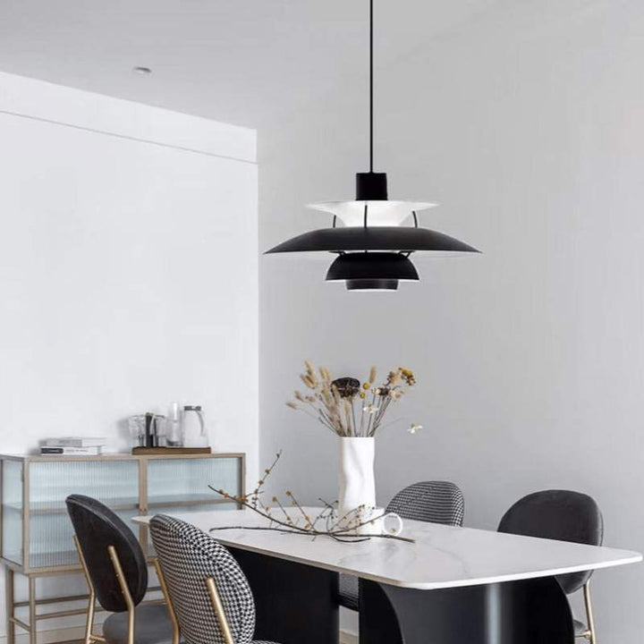 Modern dining room with a black Nordic pendant lamp, white table, and chairs.