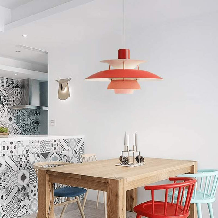 Modern kitchen with a wooden dining table and colorful chairs, featuring a red  Nordic pendant lamp.