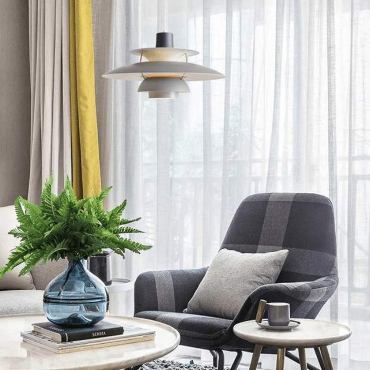 Modern living room with a checkered armchair, Nordic grey pendant light, coffee table, and decorative elements.