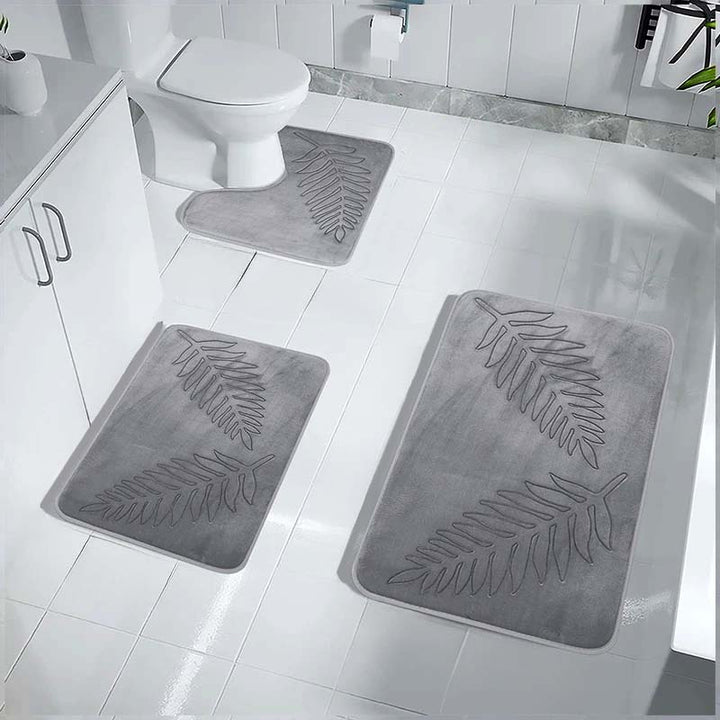 Grey bath mats with leaf pattern on a bathroom floor