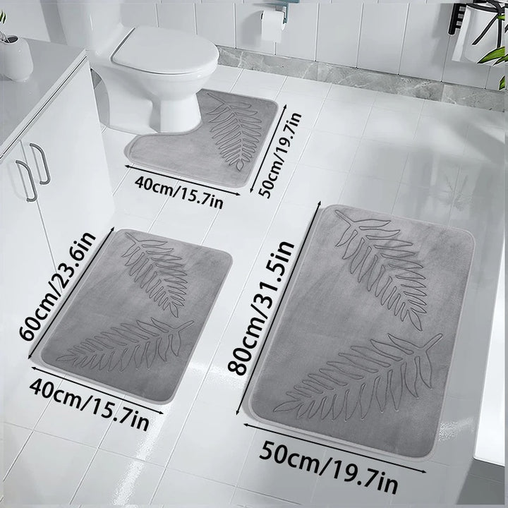 Grey bath mats with leaf pattern on a bathroom floor, showing measurements.
