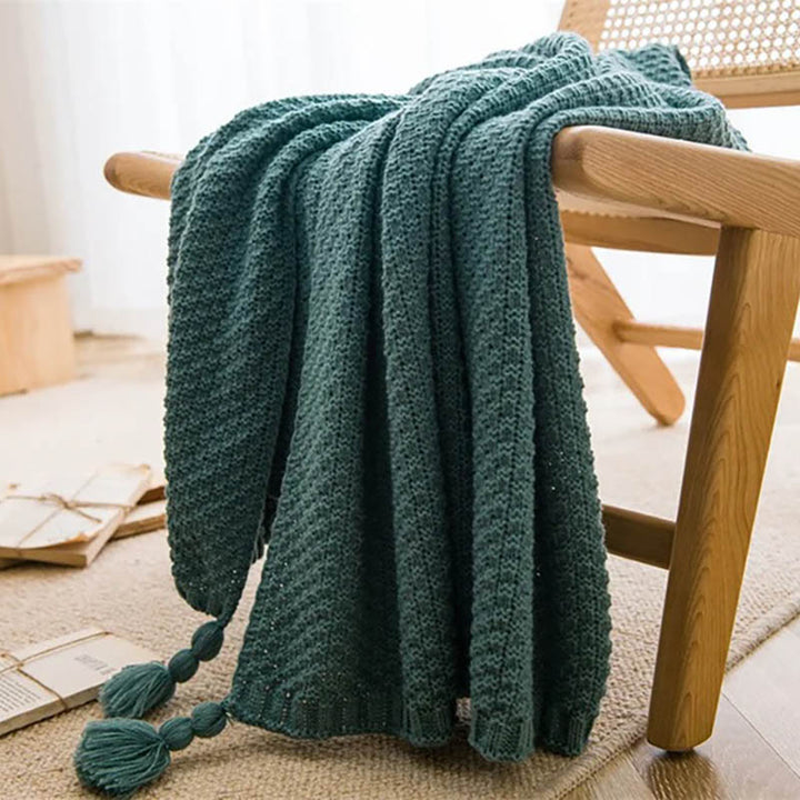 Neutral-toned Nordic knitted throw blankets with tassels, soft cotton blend, folded on chair, ideal for sofa or bed. Light Blue