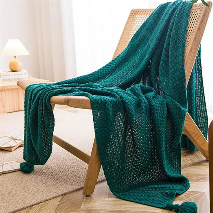 Neutral-toned Nordic knitted throw blankets with tassels, soft cotton blend, folded on chair, ideal for sofa or bed. Green
