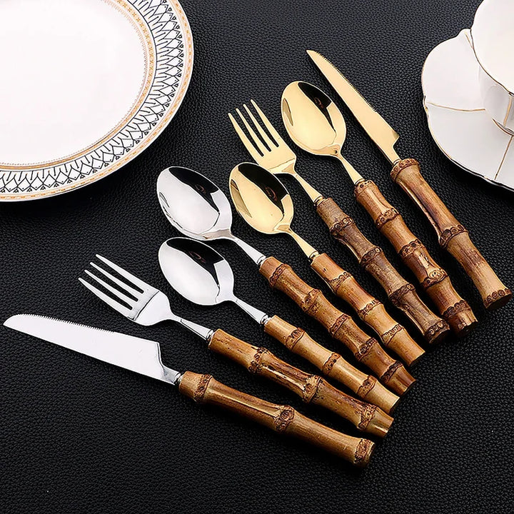 Set of silverware with bamboo handles on a black surface
