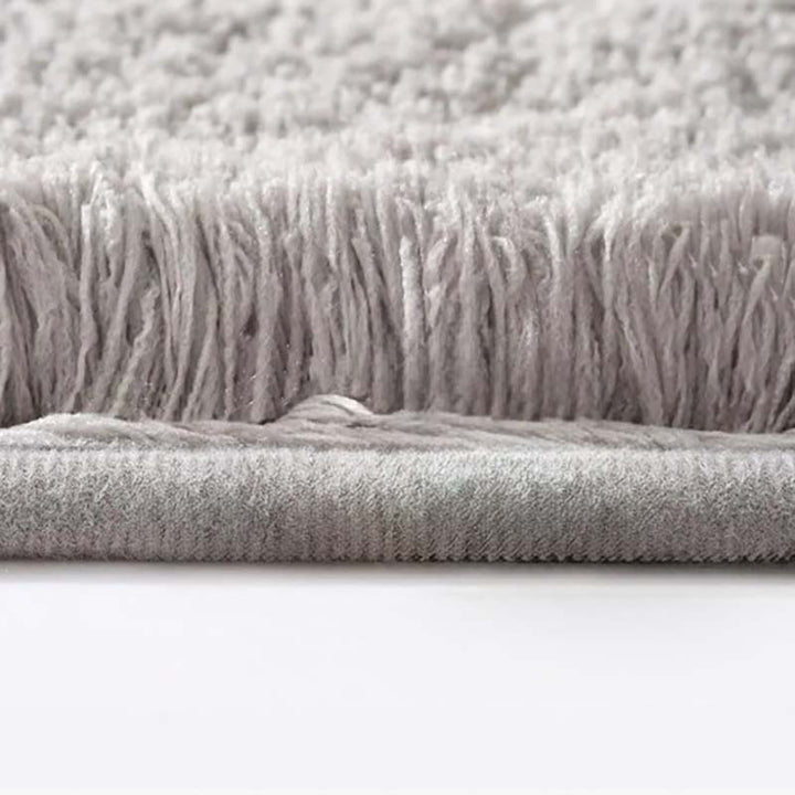 Close-up of a textured gray fabric with fringes on a white background