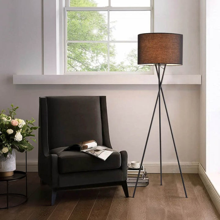 Modern living room with a dark gray armchair, floor lamp, and window view.