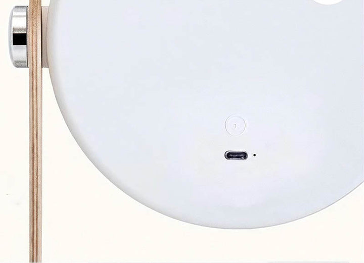 LYKT lamp charging port with minimal touch control button, shown on modern white base and light wood handle.