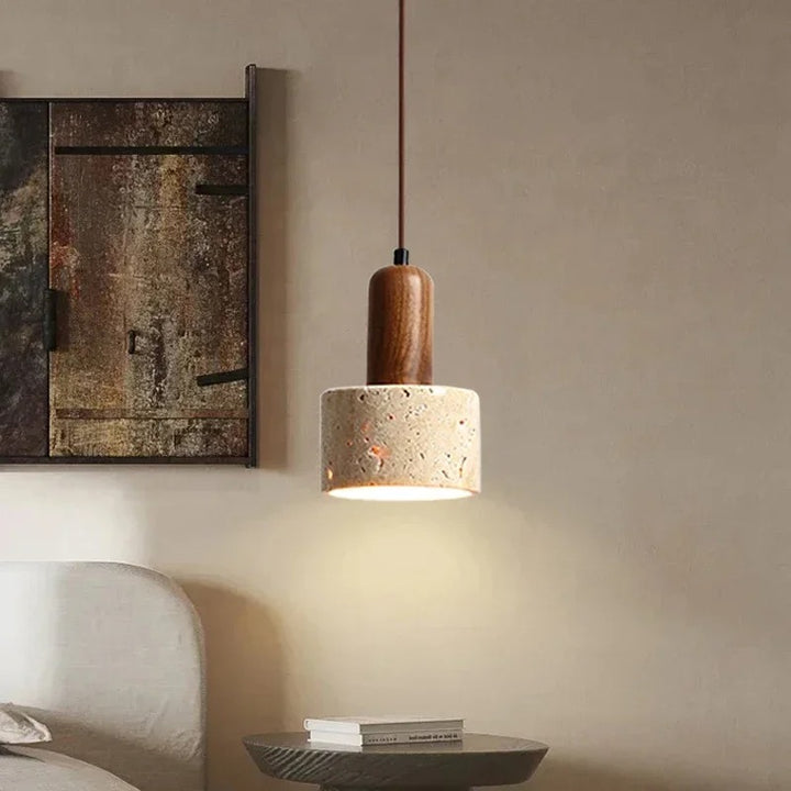 Modern pendant light with wooden top and concrete base in a room setting.