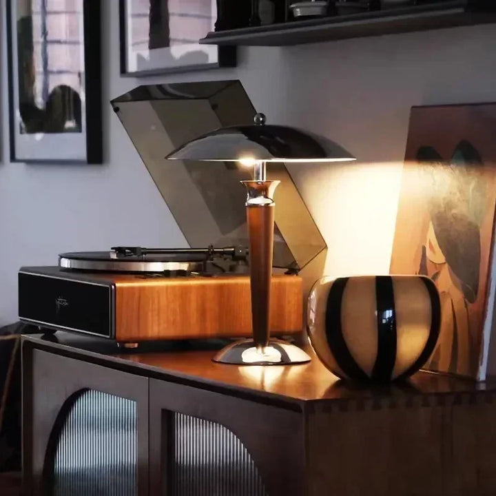 Bedside table with Scandinavian wooden desk lamp featuring chrome dome shade