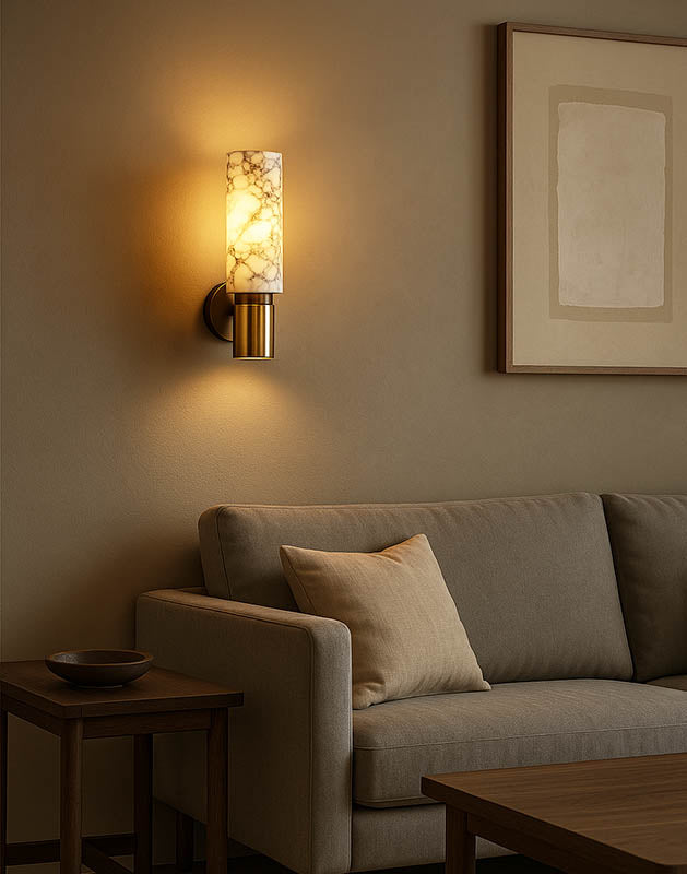 Warm LED marble wall sconce with brass base in cosy living room, perfect for Scandinavian or minimalist home styling.