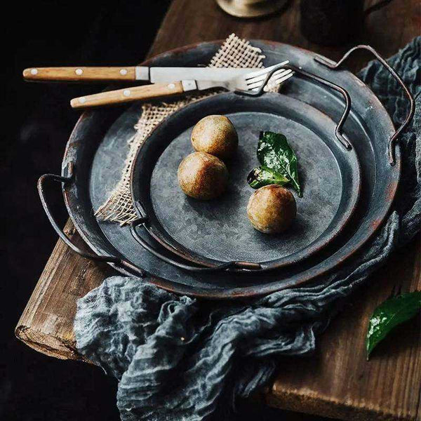 Metal trays with food items on a wooden surface complement boho interiors and natural table settings.