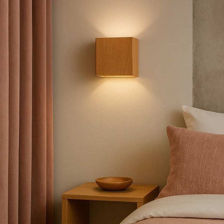 Modern wooden wall light with oak finish LED sconce above bedside table in Scandinavian bedroom