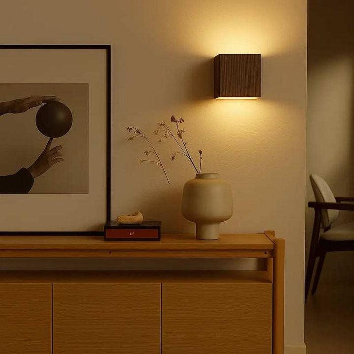 Dark brown wooden LED wall lamp glowing warmly above console table in modern home interior