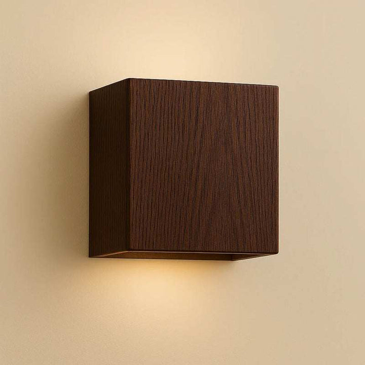 Close-up of walnut finish wooden cube wall light with warm LED glow for Nordic interiors