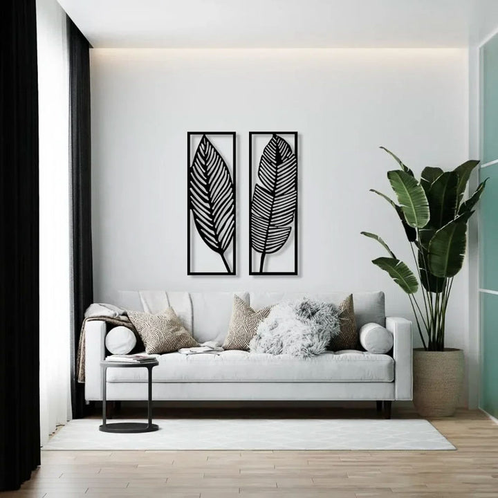 Modern living room with a white sofa, decorative pillows, and a leaf-themed wall art.