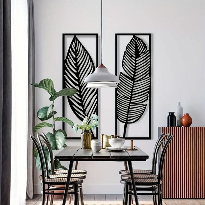 Dining room with black leaf-shaped wall art, a table, chairs, and decorative items.