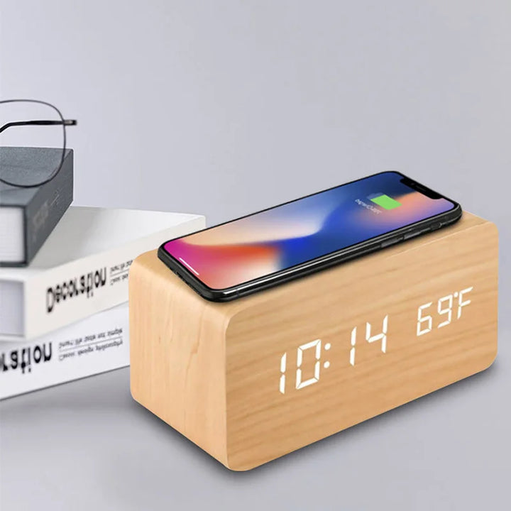 Natural wood alarm clock with smartphone charging wirelessly on top of LED display