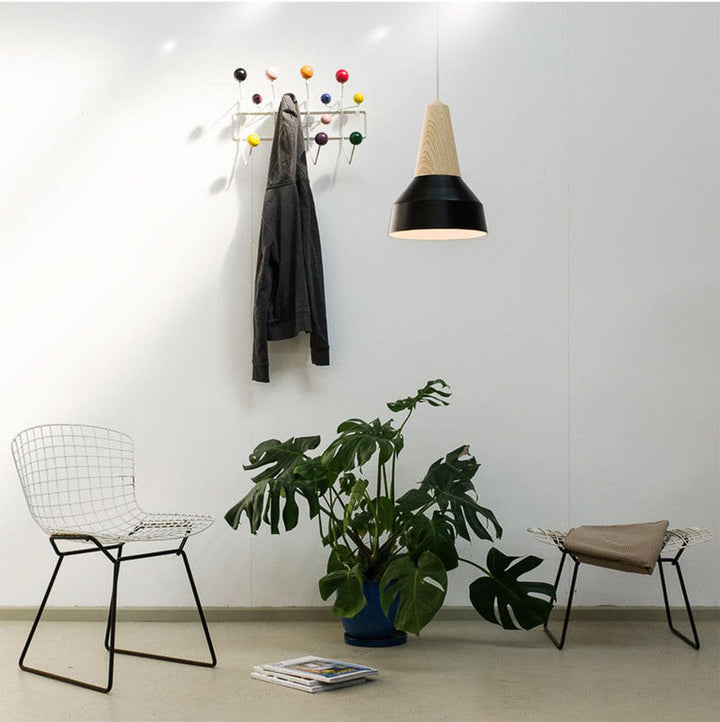 Modern interior with a plant, chairs, and a wall hook with colorful balls.