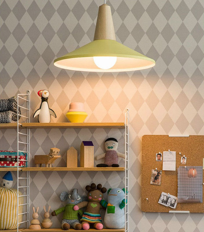 Shelving unit with toys and a green pendant lamp against a patterned wall.