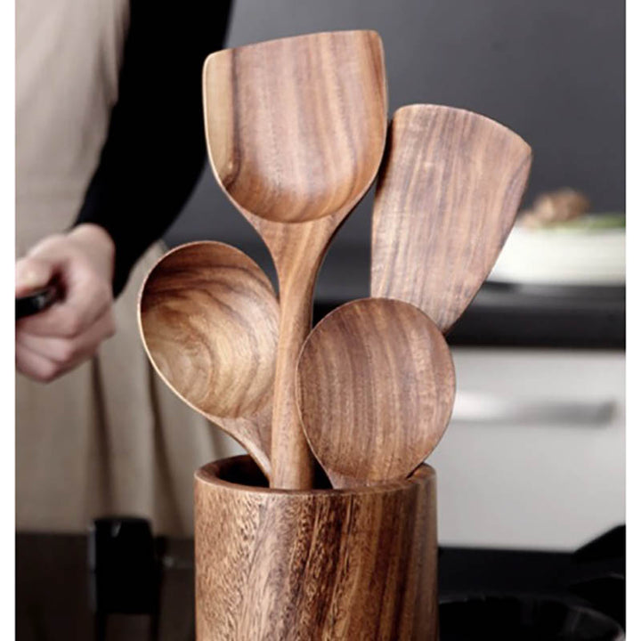 Set of wooden spoons in a wooden holder with a blurred background