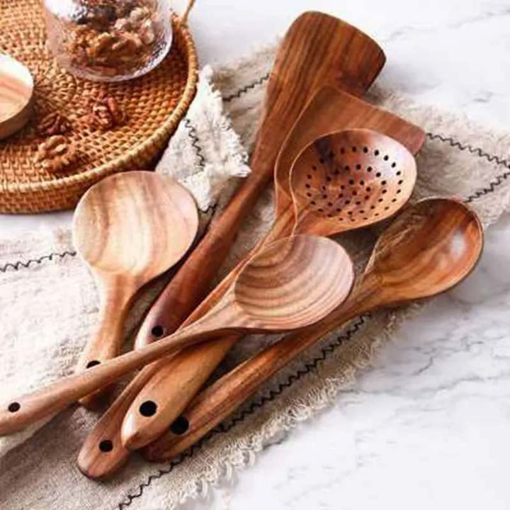 Set of wooden cooking utensils on a textured surface