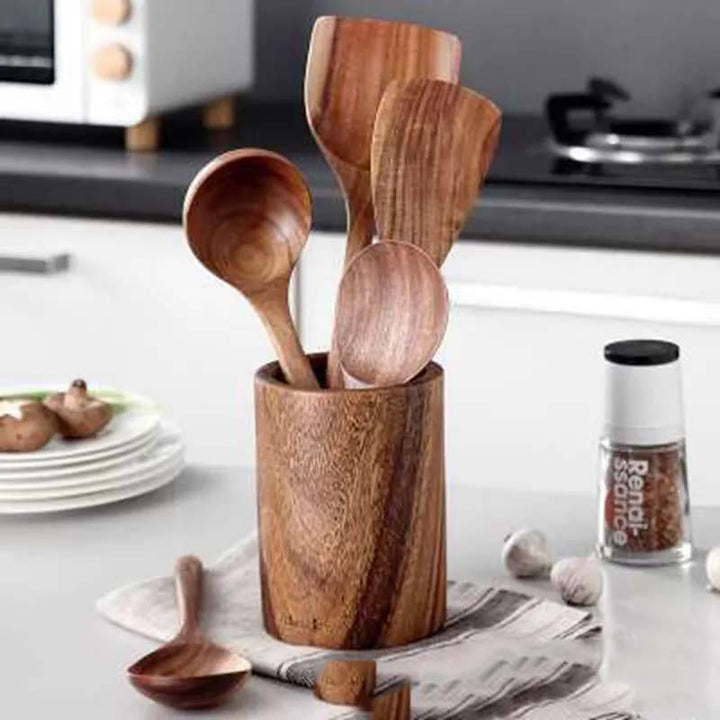 Wooden kitchen utensils in a holder on a kitchen counter