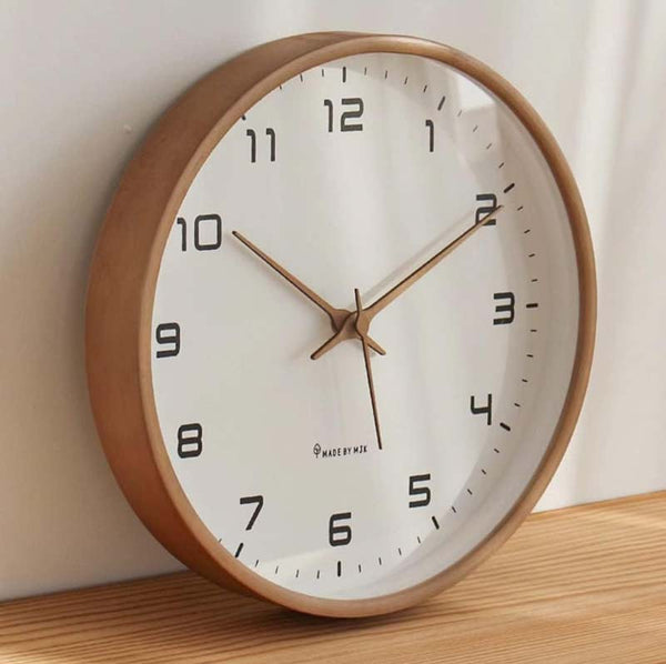 Wooden wall clock with white face on a wooden surface