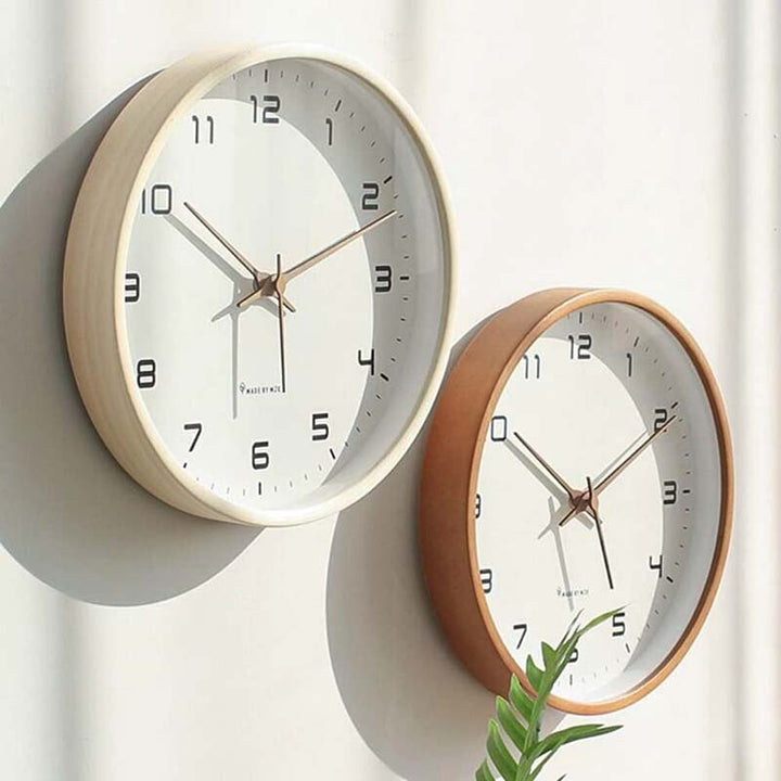 Two wooden wall clocks with wooden frames on a light background