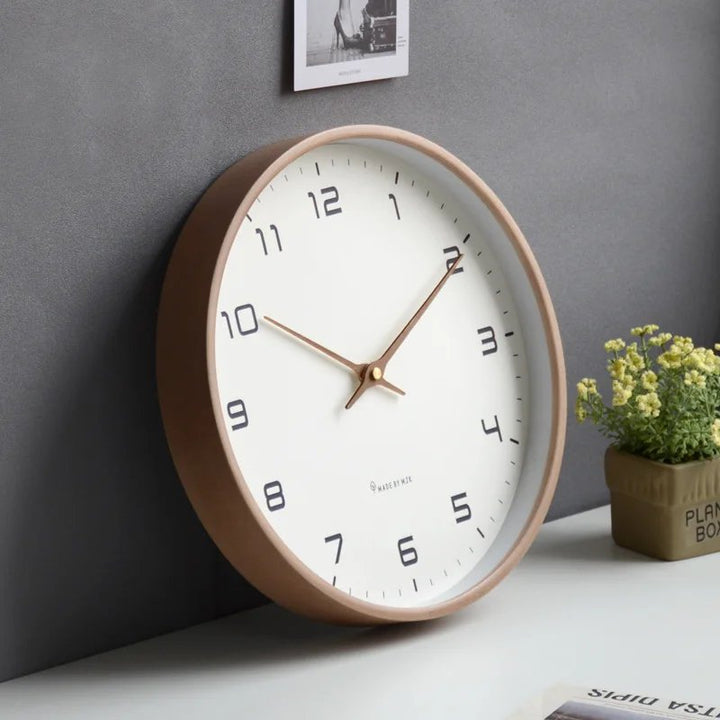 Wooden Round wall clock with a brown frame on a gray wall background