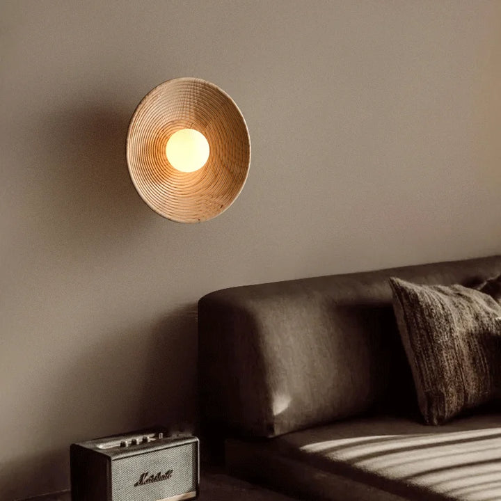 SFARISK wall lamp placed above a sideboard with vases, showing its subtle glow in a Scandi-style hallway.