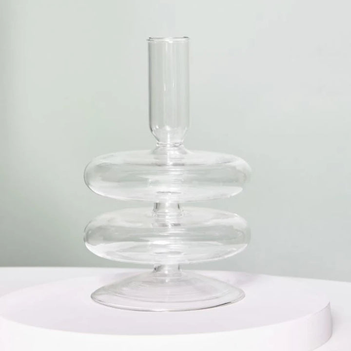 Clear glass double-ring candle holder with minimalist modern silhouette on round white display stand