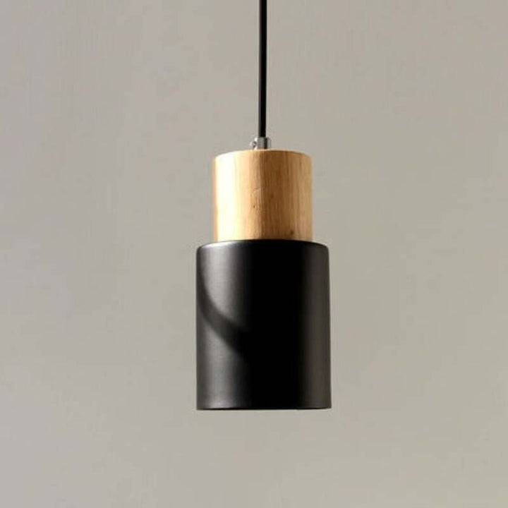 Single black wood-and-metal pendant light with cylindrical shape and minimalist aesthetic.