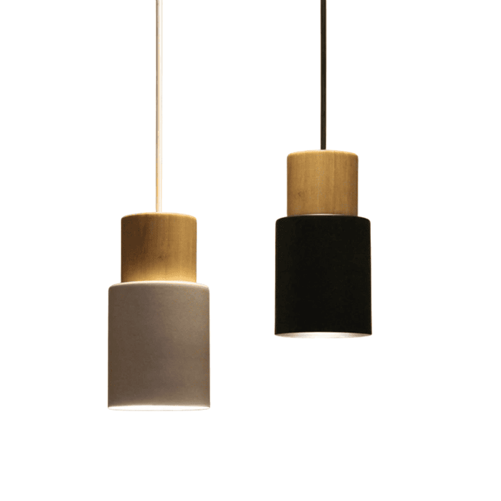 Pair of black and white pendant lights with wood tops hanging against neutral background, modern home lighting.