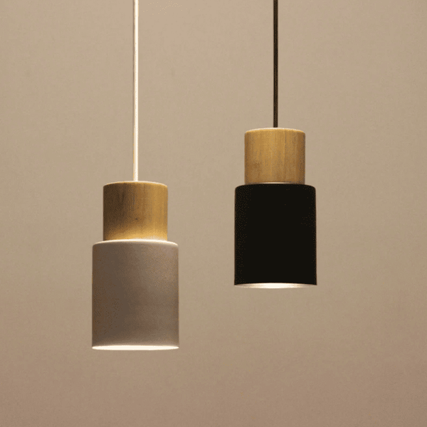 Two-tone pendant lights in black and white emitting soft glow, ideal for warm minimalist interiors.