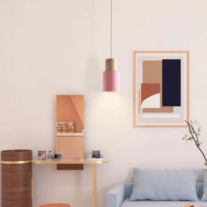 Pink wooden pendant light illuminating a pastel-toned living space with Scandinavian-inspired décor.