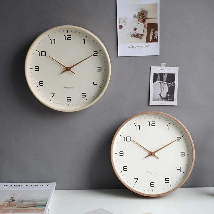 Two minimalist wall clocks on a grey wall with decorative photos.