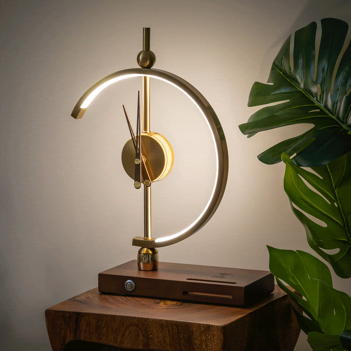 Modern gold LED lamp clock with rotating hands and wooden charging base on a side table.