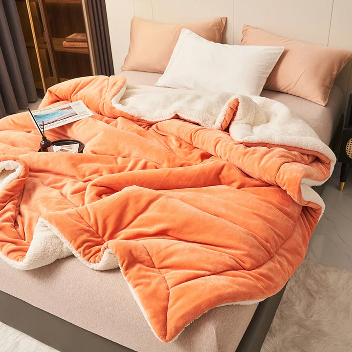 Burnt orange fleece blanket with cream sherpa lining on bed, Scandinavian-inspired comfort throw for home