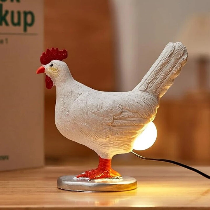 Playful white chicken-shaped table lamp with warm LED glow on wooden surface