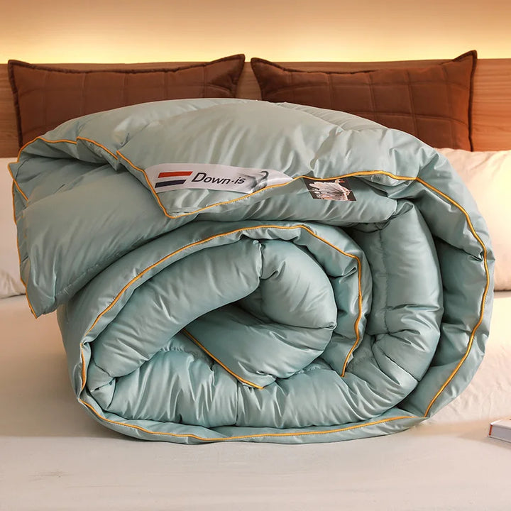 Rolled light blue goose down comforter with quilted sections and soft hotel-style padding.