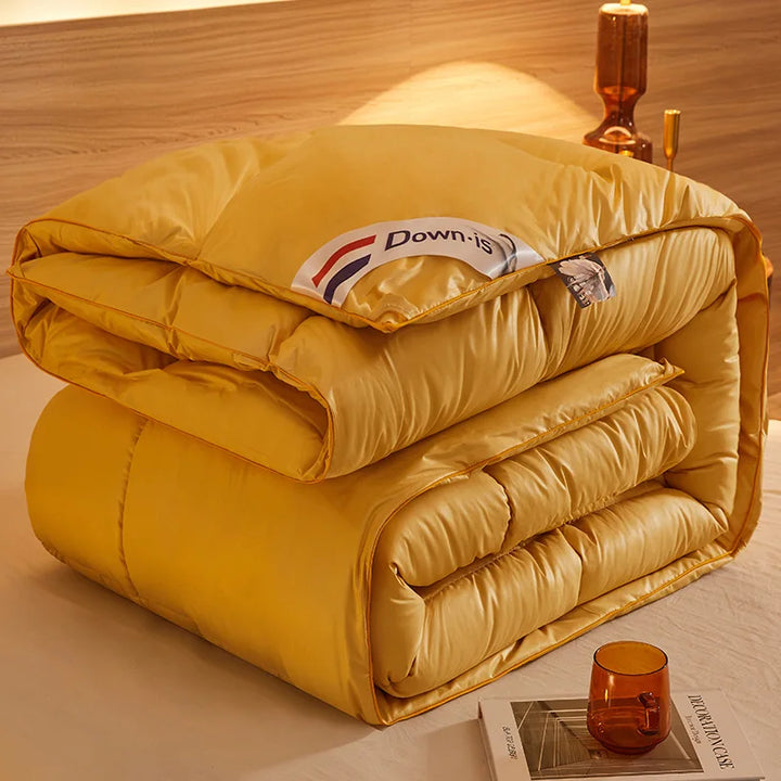 Yellow goose down comforter folded with soft quilted padding and subtle piping detail.