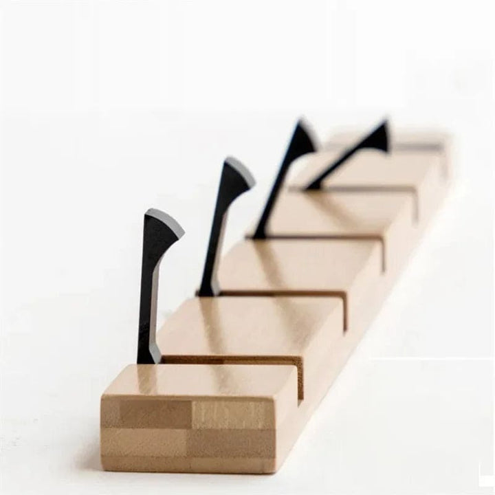 Close-up of bamboo hook rack with black flip-down hooks for coats, bags or towels.