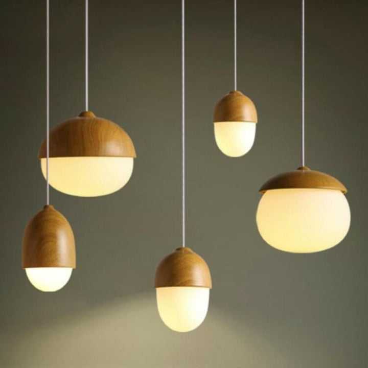 Warmly lit wooden pendant lamps in varying shapes, Scandinavian modern cluster lighting.