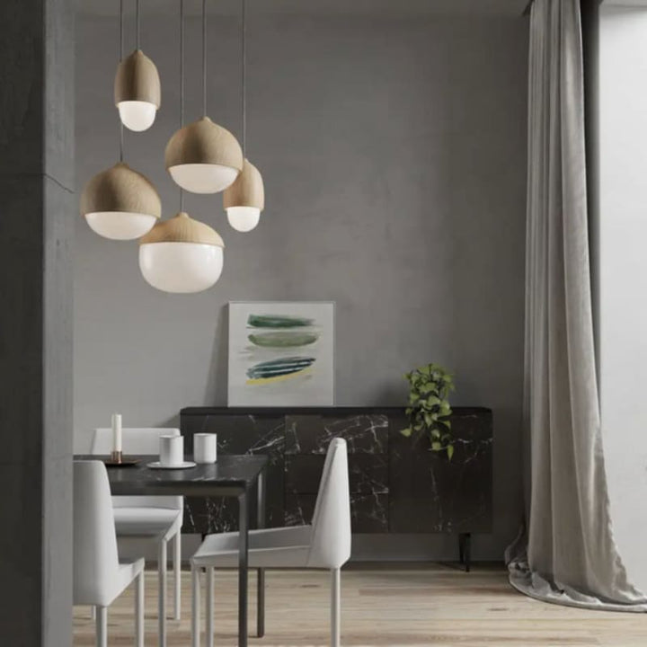 Scandinavian-style dining room with cluster of faux wood pendant lights above black marble table.