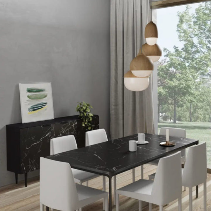 Wooden pendant lamps hanging above a dining table, soft ambient glow for modern interiors.