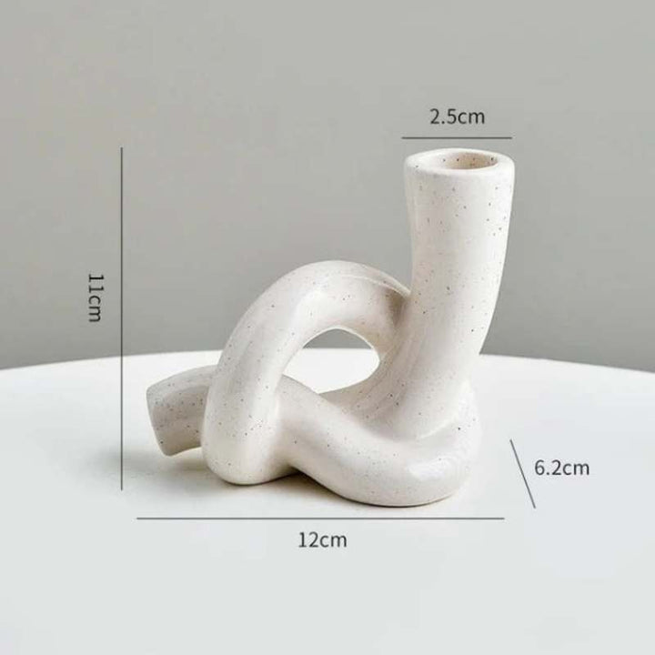Sculptural white ceramic knot candle holder with size measurements in cm