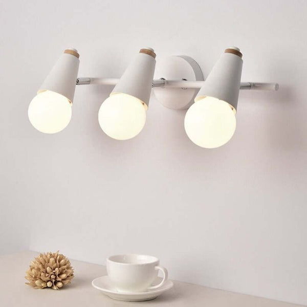 Angled view of triple white wall sconce above a cup, modern Nordic lighting for cosy spaces