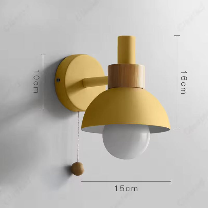Yellow and wood wall lamp with globe bulb, measuring 15 cm (5.9 in) wide × 16 cm (6.3 in) high × 10 cm (3.9 in) deep.
